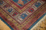 Khotan carpet corner with sapphire blue, cherry red, gold borders, plush pile, and fringe.