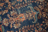 Detail of antique Persian Mahal rug: navy field, blossomed floral motifs, low pile texture.