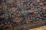 Mahal rug's low pile texture, showing navy, terra cotta, and time-softened green blossomed floral motifs.