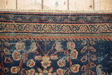 Antique Mahal carpet border with stylized vine pattern, navy, terra cotta, and visible pile wear.
