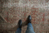 Distressed Mahal carpet's textural pile, copper terracotta, ivory, and blue henna plant motif.