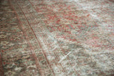 Close-up of distressed vintage Mahal rug, revealing visible foundation and faded henna plant motifs.