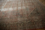 Worn copper terracotta field meets detailed patterned border of a distressed Mahal rug.