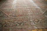 Distressed copper terracotta Mahal carpet corner, showing floral motif and exposed knot heads.