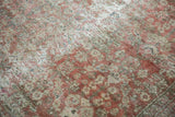 Worn copper terracotta Mahal carpet, showing henna plant motif and exposed foundation.