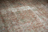 Distressed Mahal carpet texture with worn copper terracotta henna plant motifs.