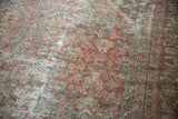 Distressed texture of a vintage Mahal carpet, revealing copper terracotta hues, worn henna design, and border.
