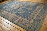 Distressed vintage Sparta rug showing faded royal blue field, scrolling tendrils, and terracotta border motifs.