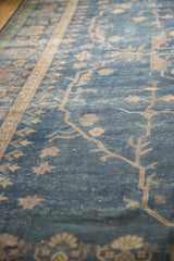 Distressed royal blue field with faded terracotta scrolling tendrils of a Sparta carpet.