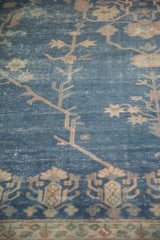 Distressed royal blue field of this vintage Sparta carpet, showing faded floral patterns and exposed foundation.