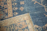 Folded corner of vintage Sparta carpet, showing distressed royal blue pile, beige foundation, and terracotta motifs.
