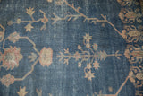 Distressed Sparta rug's faded royal blue field with scrolling terracotta floral interpretations.