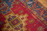 Stepped beige medallion and blue-purple geometric patterns on a cherry red vintage Turkish rug field.