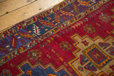Colorful, serrated main border with geometric patterns on the cherry red field.