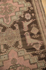 Distressed Karabagh rug features pale blush rose florals and inwardly facing birds.