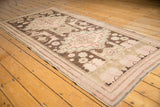 Distressed antique Karabagh runner showing blush medallions, charcoal birds and florals, plus visible wear.