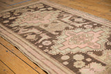 Distressed antique Karabagh runner's blush rose and charcoal floral pattern, showing soft patina.