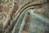 Distressed vintage Hamadan rug texture with muted blues, greens, and terracotta tones.