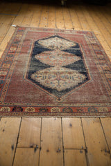 Antique Afshar rug corner detail: madder root red field, navy serrated outline, visible wear.
