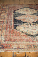Low pile of antique Persian Afshar rug with madder red border and serrated navy medallion.