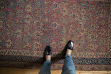 Underfoot view of a Persian Malayer rug, highlighting plum floral panels and a navy geometric border.