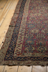 Antique Malayer rug: low pile plum field with floral blossoms and intricate navy, beige border.