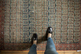Antique Heriz fragment rug's staggered boteh pattern in navy, blush, and ivory tones.