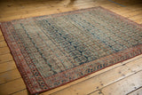 Intricate red border and faded navy, blush, ivory boteh motifs on this antique Heriz fragment.