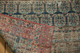 Antique Heriz rug's flipped corner, displaying hand-knotted foundation and navy, blush, ivory boteh pattern.