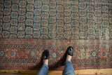 Navy boteh patterned field and geometric red border on an antique Heriz carpet.