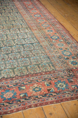 Hand knotted antique Heriz rug with blush and blue floral border, softened texture.