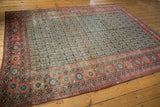 Antique Heriz carpet border in rust, featuring faded navy boteh germinating plants.
