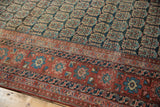 Blush, sky blue antique Heriz border with navy boteh field, showing mostly even pile wear.