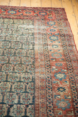 Antique Heriz carpet with repeating boteh motif, worn textured pile, and blush ivory tones.