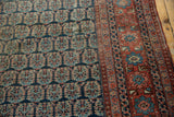 Antique Heriz carpet, showing geometric border and navy field with staggered boteh motifs.