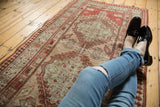 Vintage distressed Serab runner with low pile, faded sand, terra cotta, and red tones.