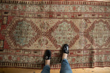 Distressed vintage Serab runner with central diamond medallions, sand, and muted terra cotta hues.