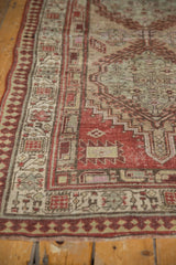 Distressed vintage Serab runner's low pile, revealing terra cotta and sand pawn design border.