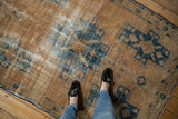 Worn pile and distressed texture of a vintage Hamadan rug in navy and sand tones.