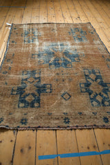 Vintage distressed Hamadan rug with worn sand and navy blue geometric motifs.