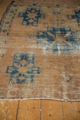 Localized wear on distressed vintage Hamadan rug, revealing knot heads and navy blue design.