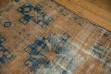 Distressed vintage Hamadan rug detail with geometric patterns, navy, and apricot tones.