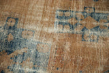 Distressed Hamadan rug detail with localized wear, sand, and navy blue foundation.