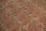 Distressed Afghan Bokhara rug's low pile, showing chestnut and time-softened silver guls.