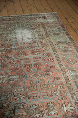 Distressed vintage Mehrivan rug showing worn geometric patterns in faded red and blue.
