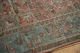 Rectilinear geometric motifs on distressed Mehrivan rug in dusty terra cotta and slate blue palette.
