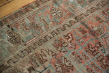 Distressed Mehrivan carpet pile detail with geometric flora in terra cotta and slate blue.