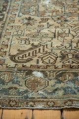 Distressed Mehrivan rug's geometric motifs and wear revealing foundation in muted tones.