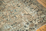 Distressed geometric field in antique ivory, blues, and brown, with textural low pile.