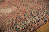 Distressed Malayer rug detail: muted madder red field, Mir Boteh pattern, and antique ivory border.